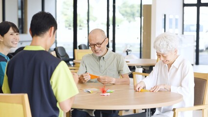 介護施設で折り紙を折るアジア人高齢者