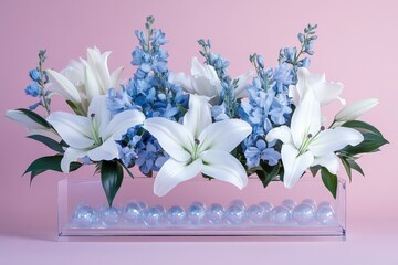 Obraz premium A delicate arrangement of white lilies and light blue delphiniums sits gracefully in a clear acrylic box, creating a serene and elegant display.