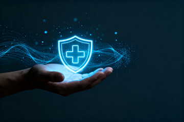 A hand holding a glowing blue shield with a medical cross, symbolizing healthcare protection and digital security.