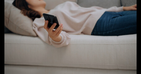 Young Asian woman with depression and fainting in living room at home and holding the mobile phone
