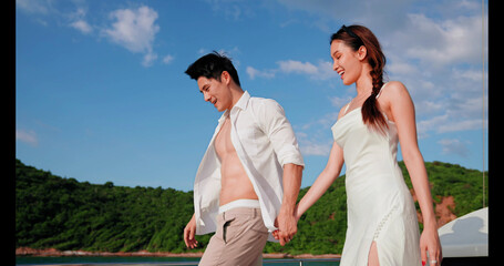 Asian couple holding hands together on a yacht