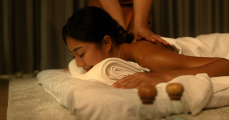 Young Asian woman getting a back massage from the staff in the spa Thai massage