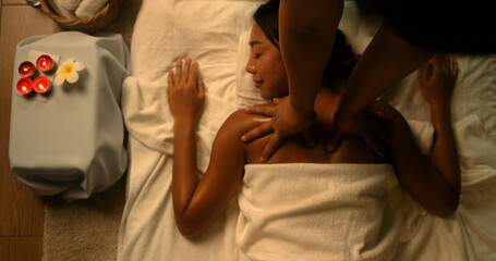 Young Asian woman getting a back massage from the staff in the spa Thai massage