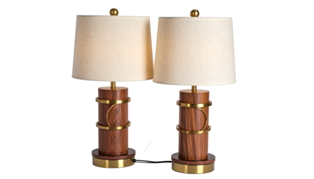 Two matching wooden table lamps with cream-colored shades.  The bases are cylindrical, with a wood grain texture, and gold-toned bands encircling the midsection.  The lampshades are simple and soft