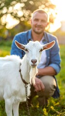 Obraz premium A man and a goat in a field at sunset