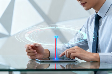 Man interacting with a futuristic holographic interface on a tablet in a modern office setting