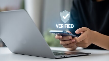 Woman verifies identity on smartphone with laptop for secure online access