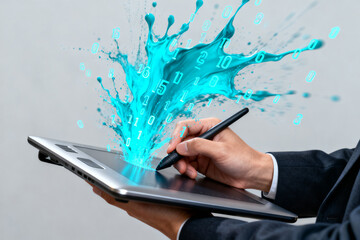 Person using digital tablet with stylus, creating a splash of blue digital data and numbers