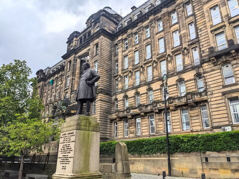 Statue of James Lumsden before the grand facade of Glasgow's historic Royal Infirmary building
