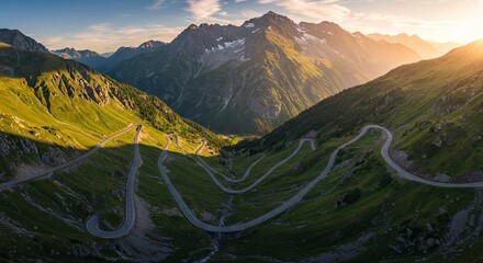 Winding road ascends through green valleys towards majestic mountains under bright sun