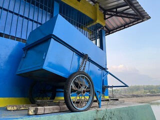 Large blue metal water tank on a raised platform under clear daylight, symbolizing rural infrastructure and water storage