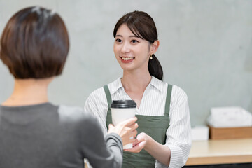 カフェでドリンクを渡す女性