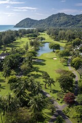 An expansive view of a tropical golf course, showcasing lush greenery, a serene lake, and rolling hills meeting the ocean.