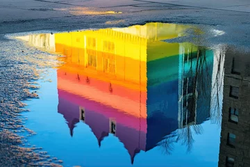 Wanddecoratie Reflectie Vibrant rainbow-colored church reflected in puddle of water on urban street creating stunning colorful scene adding depth and visual appeal combining architecture with nature  © wilson