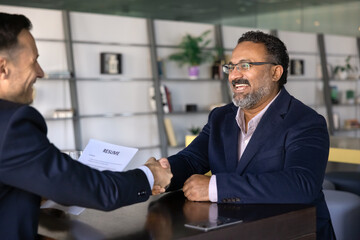 Fototapeta premium Older male applicant firmly shaking hands with interviewer