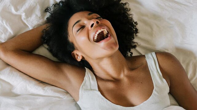 Female alone pleasures herself. Strong emotions and feelings, female feeling, satisfying, desire and loss of control. Young woman having orgasm in bed.