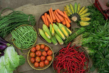 A vibrant display of fresh vegetables like ripe tomatoes, crunchy carrots, and greens at a bustling market