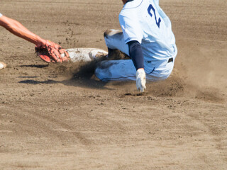 高校野球で2塁でスライディングする選手とタッチする選手