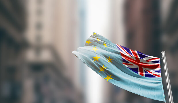 Tuvalu national flag waving on street. A beautiful with mast with blur buildings. Tuvalu national flag for independence day.