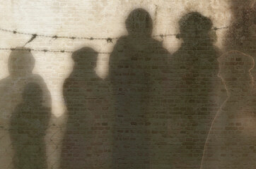 Refugee in Ukraine and Gaza and in the world showed as shadows on a wall with barbed wire