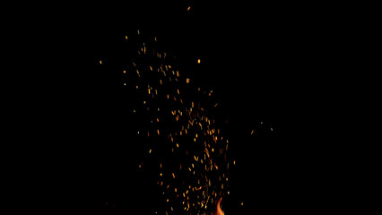 sparks and embers from campfire flying over black background