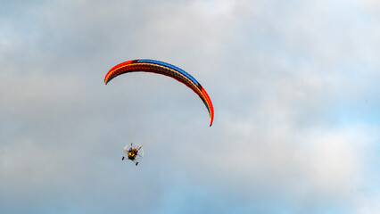 Moto glider with parachute on sunset background