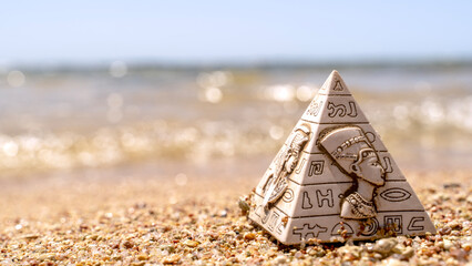 Souvenir Egyptian pyramid on the beach by the sea