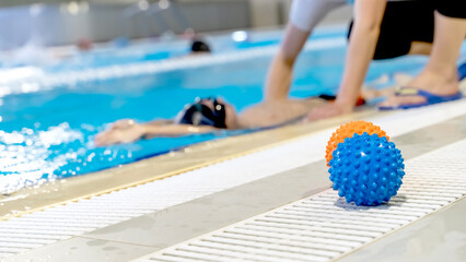 A boy in the pool to learn to swim or swim