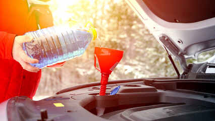 Driver pours windshield fluid in winter