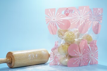 Golden mung bean cakes packed in a lovely floral bag. Soft, flaky, and sweet, they combine tradition with modern charm perfect as a gift or a delightful treat anytime. Industrial food. Free copy space