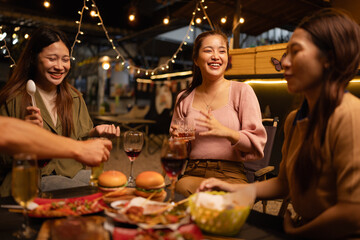 Happy Friends Celebrating Together at Night, Young Asian Group of Friends Having Fun and Toasting Drinks Outdoors, Enjoying a Celebration Concept.