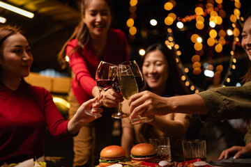 Happy Group of Woman Friends Celebrating Together at Night, Сlinking glasses of dinner at a social gathering.