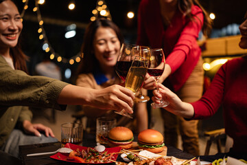Happy Group of Woman Friends Celebrating Together at Night, Сlinking glasses of dinner at a social gathering.