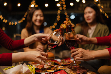Happy Group of Woman Friends Celebrating Together at Night, Сlinking glasses of dinner at a social gathering.