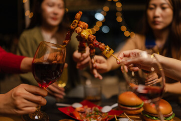 Happy Group of Woman Friends Celebrating Together at Night, Сlinking glasses of dinner at a social gathering.