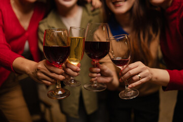 Happy Group of Woman Friends Celebrating Together at Night, Сlinking glasses of dinner at a social gathering.