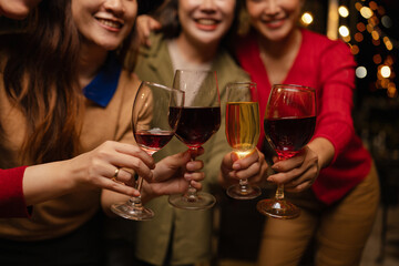 Happy Group of Woman Friends Celebrating Together at Night, Сlinking glasses of dinner at a social gathering.