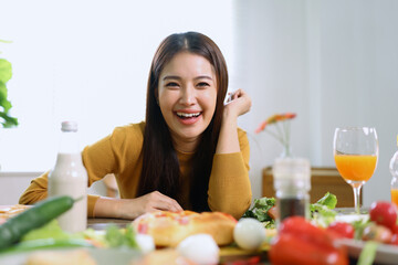 Happy young woman enjoying delicious homemade pizza at home.