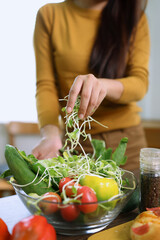 Happy young woman preparing healthy food in the kitchen.