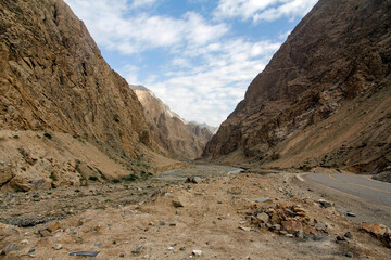 Vast and rugged mountain canyon with sparse vegetation under a cloudy sky