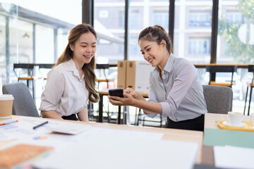 Fototapeta premium Two businesswoman colleagues having a casual conversation during a coffee break, Informal business meeting for new ideas and collaboration.