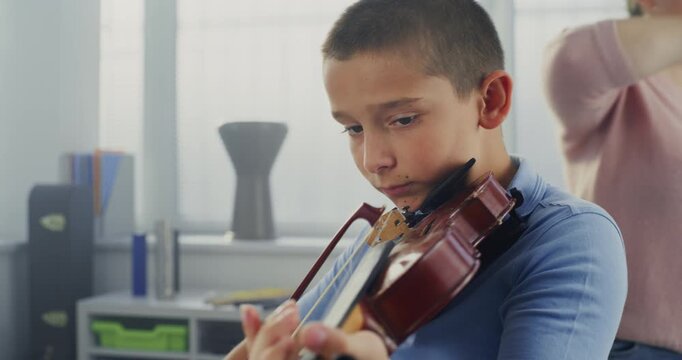 Primary School Boy Practicing Violin in Music Class, Dreaming to Become Musician. Teacher Guiding Artistic Child in Playing Musical Instrument. Musical Education, Violin Training Lesson, Rehearsal.