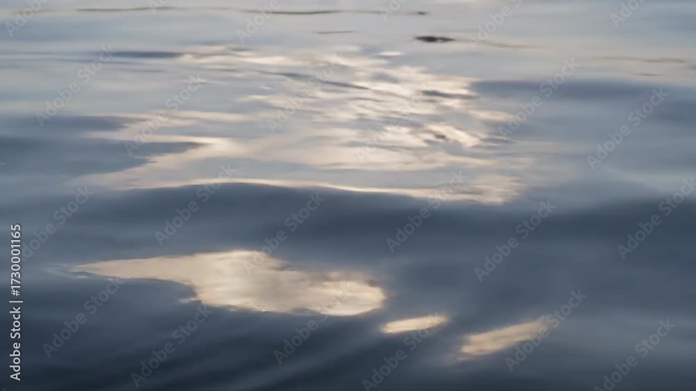 Wall mural calm water surface with subtle ripples and abstract reflections of soft light, captured with a stati