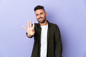 Caucasian man isolated on purple background happy and counting four with fingers