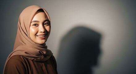 Woman in hijab smiles, studio shot