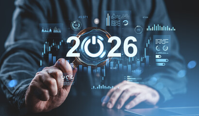 Businessman analyzing futuristic digital data graph interface with power icon and 2026 concept on transparent screen in modern technology environment.