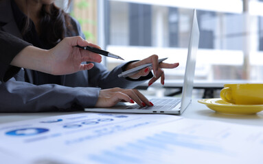 Hand of business team holding a pen, discussing marketing analytics at the office.