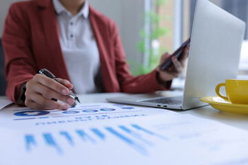 Hand of businesswoman holding a pen, discussing marketing analytics at the office.