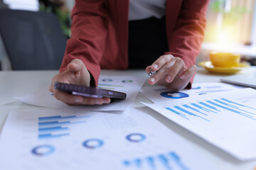 Hand of businesswoman holding a pen, discussing marketing analytics at the office.