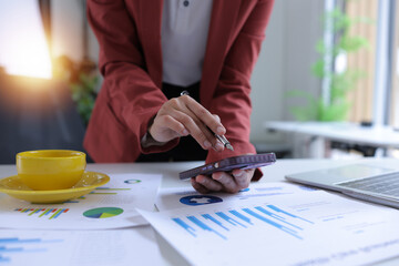 Hand of businesswoman holding a pen, discussing marketing analytics at the office.